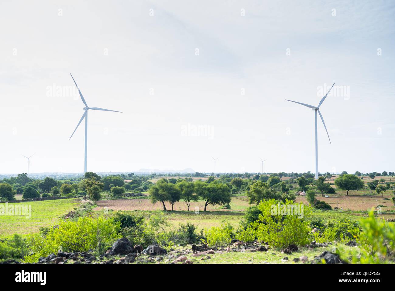 wind turbines or power plant on top of hill - concept of eco friendly, renewable energy and technology. Stock Photo