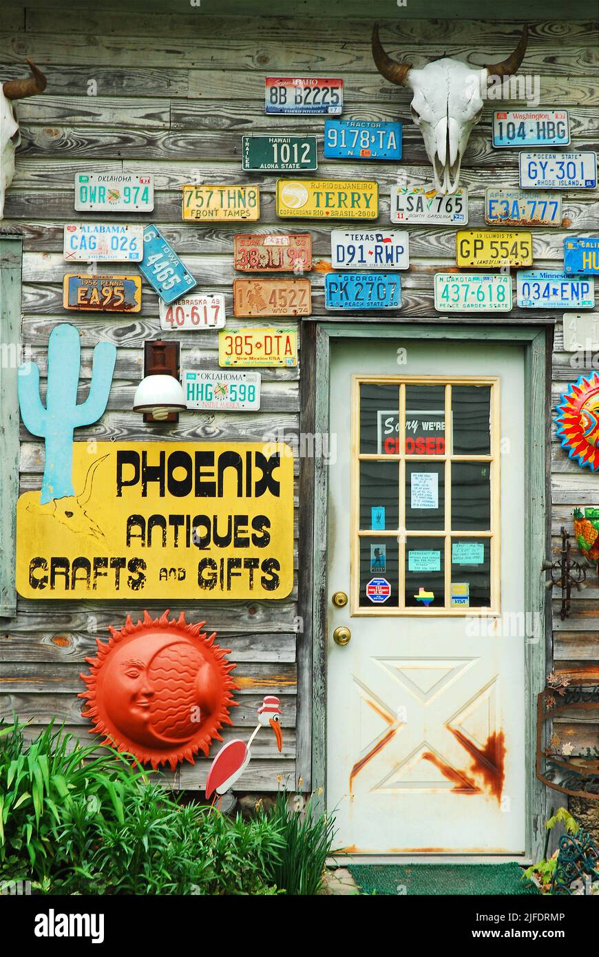 License plates from multiple states hang from the exterior wall of an antique, craft and gift shop store Stock Photo
