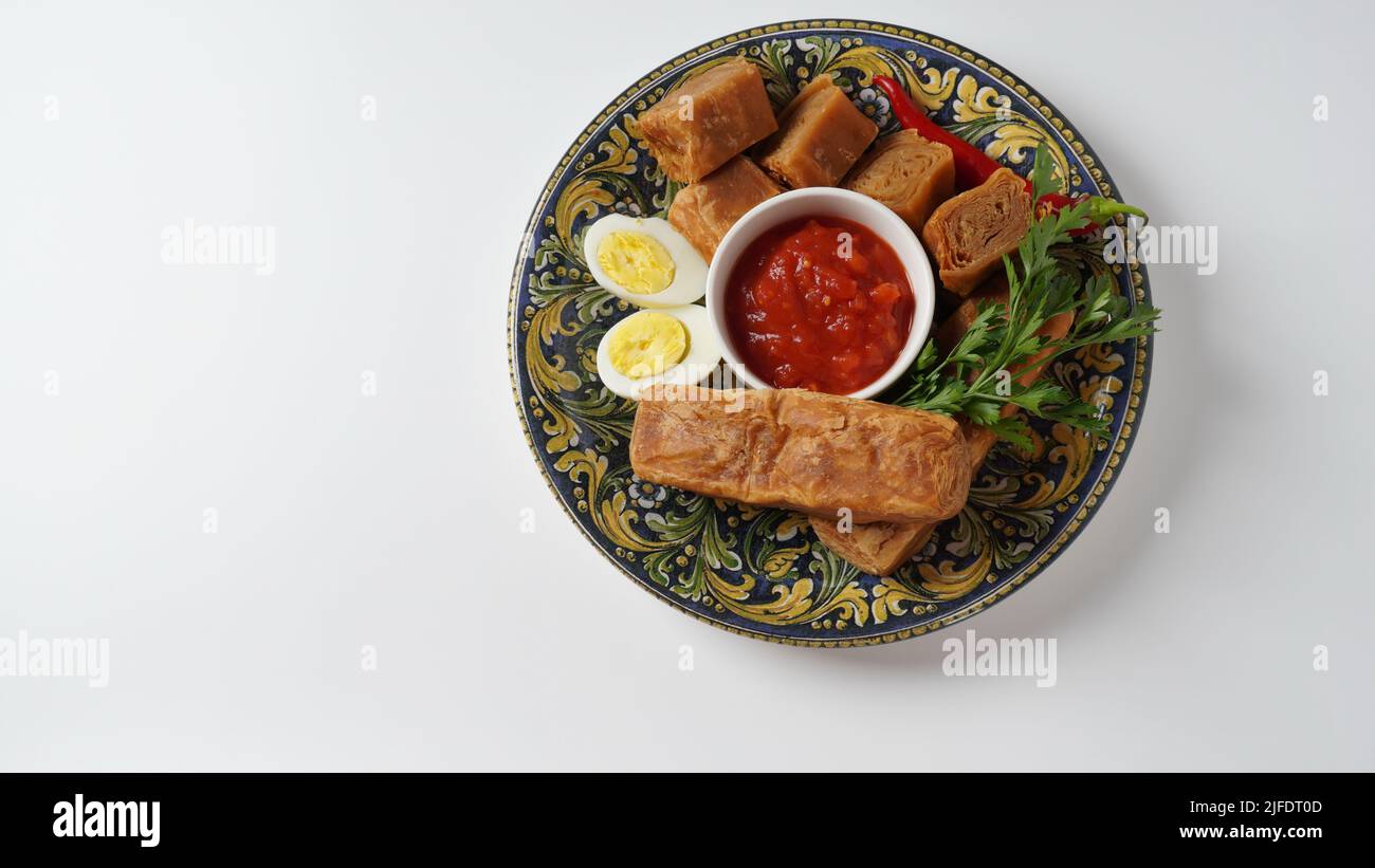 Jachnun or Jahnun, Yemenite Jewish pastry, served with fresh grated tomato and boiled egg and