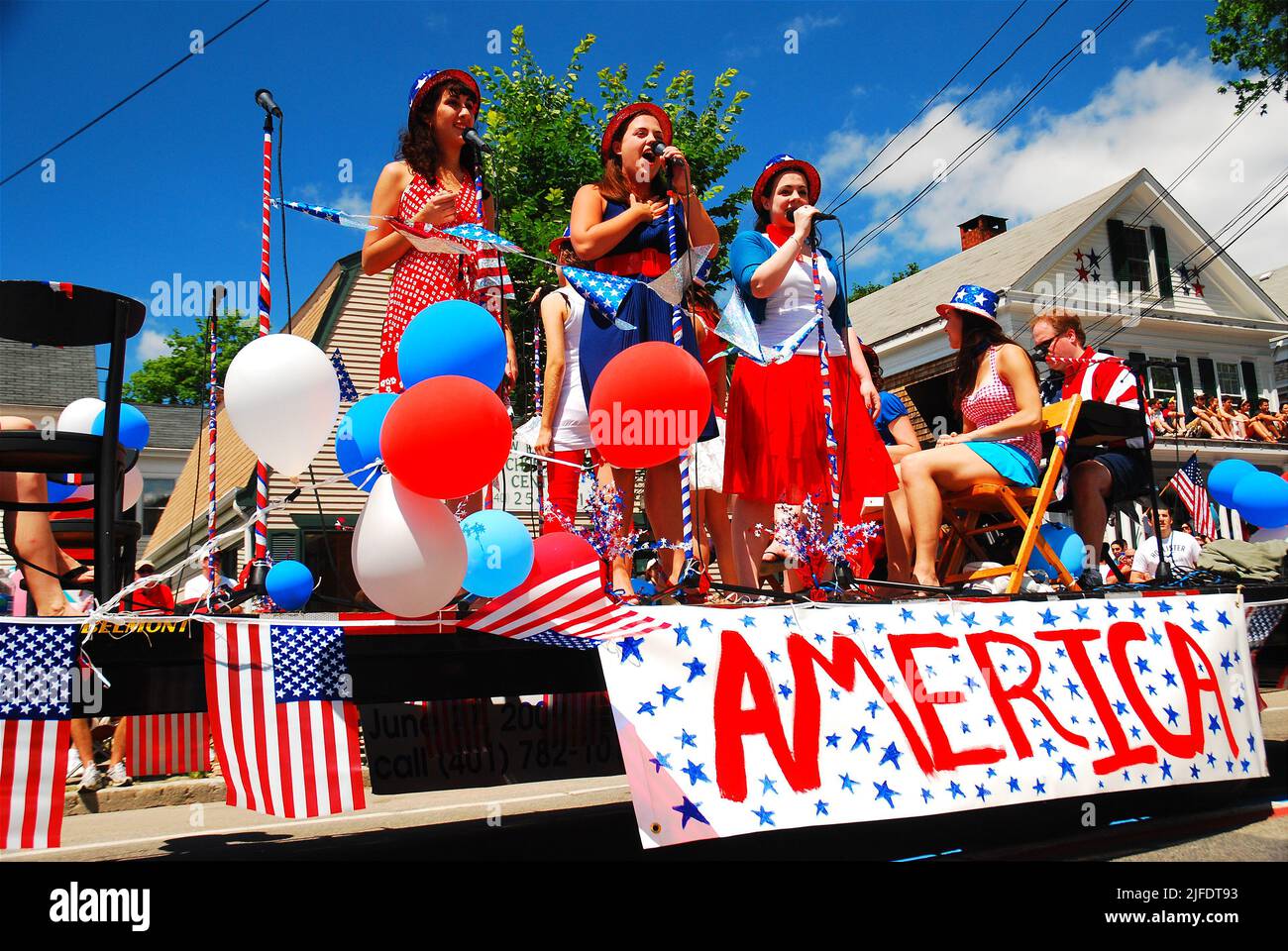 A young girl trio performs a selection of patriotic songs on a stage
