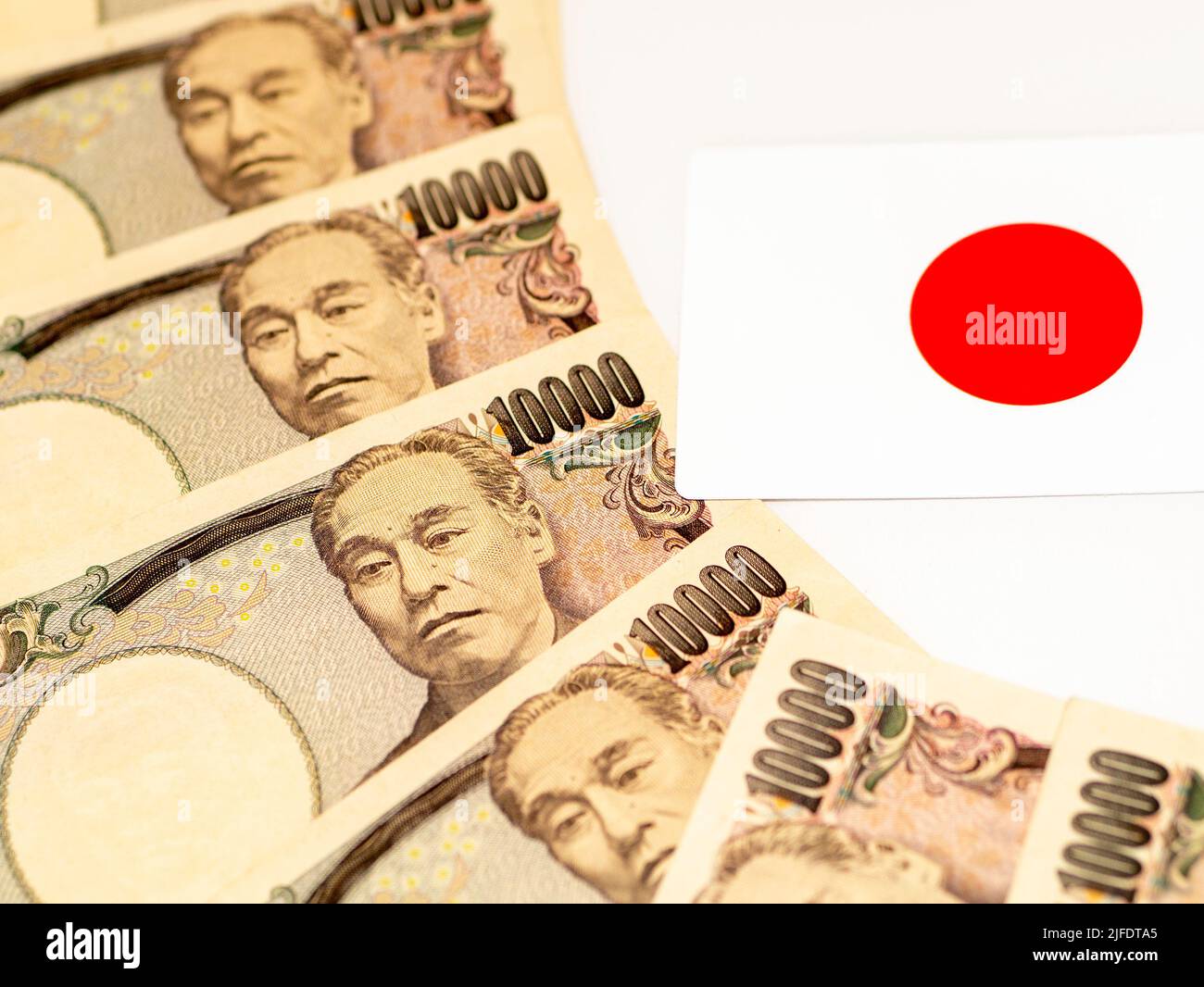 Japanese (Yen) banknotes 10.000 yen with Japanese flag. Business, Finance, World money concept, inflation and economy concept Stock Photo