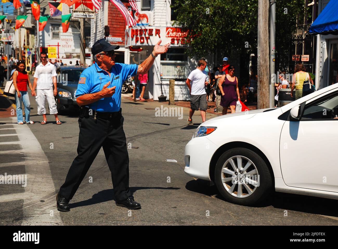 the Dancing Cop, A traffic police officer directs cars safely through a busy intersection during the hectic summer season in Provincetown, Cape Cod Stock Photo