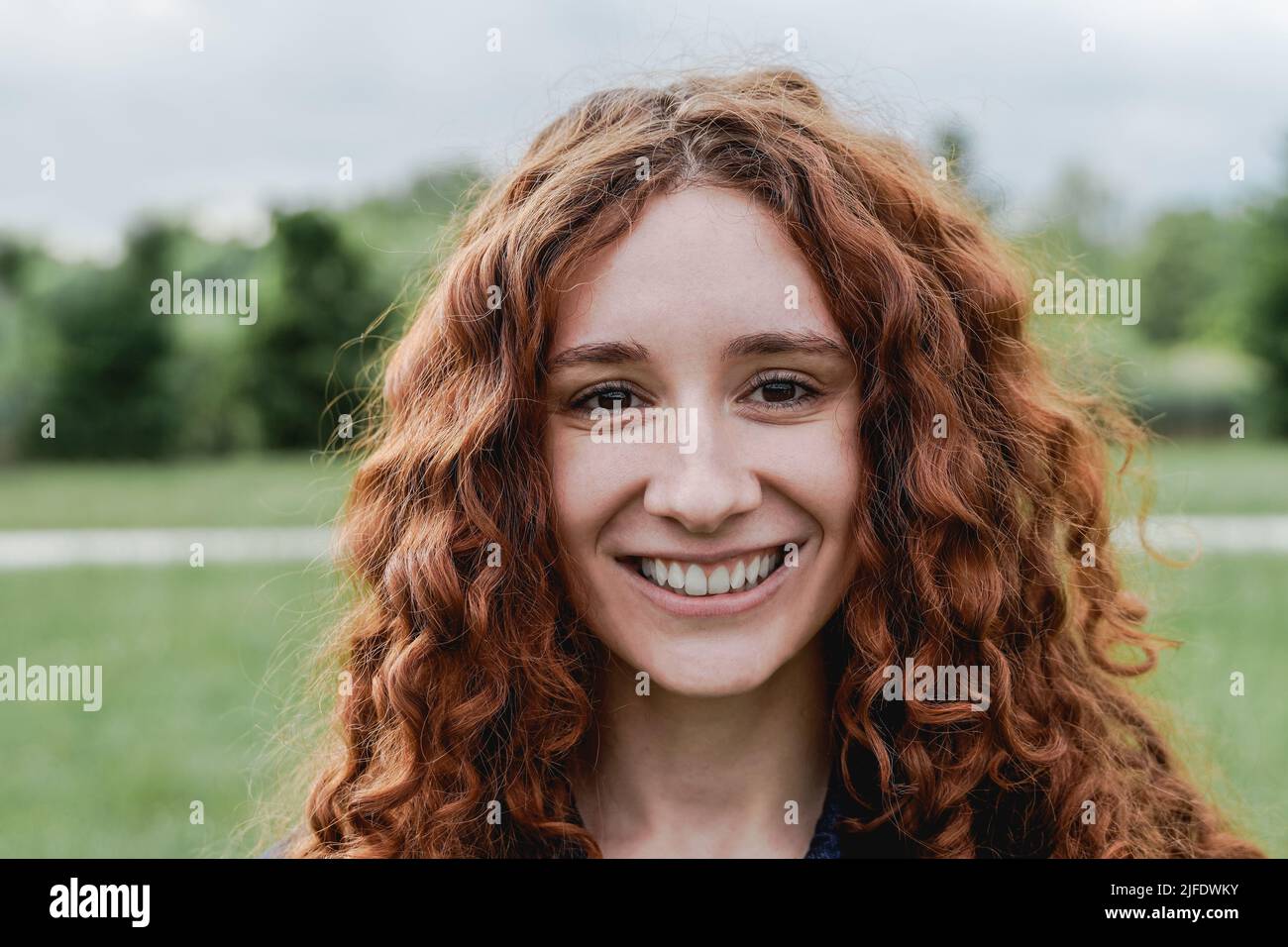 Happy ginger girl smiling on camera outdoor - Focus on face Stock Photo