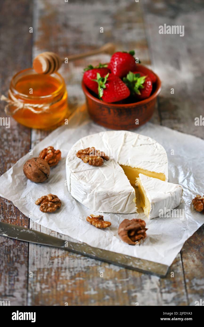 Camembert cheese with nuts, honey and strawberries. Stock Photo