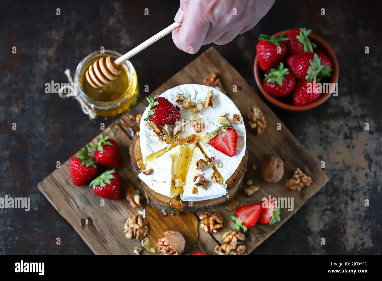 Camembert cheese with nuts, honey and strawberries. Stock Photo