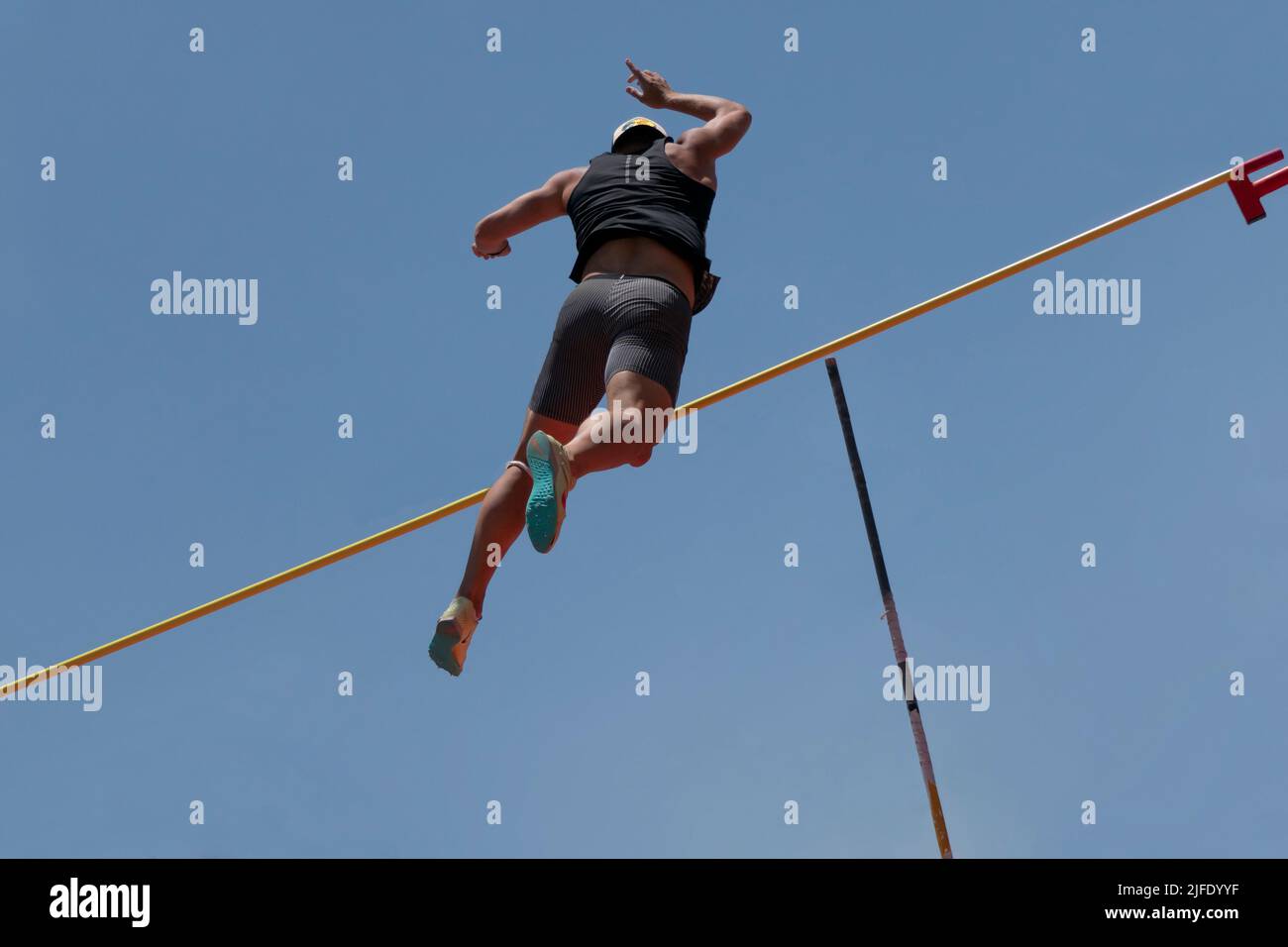 An athlete passes the bar with the aid of a pole during pole vaulting