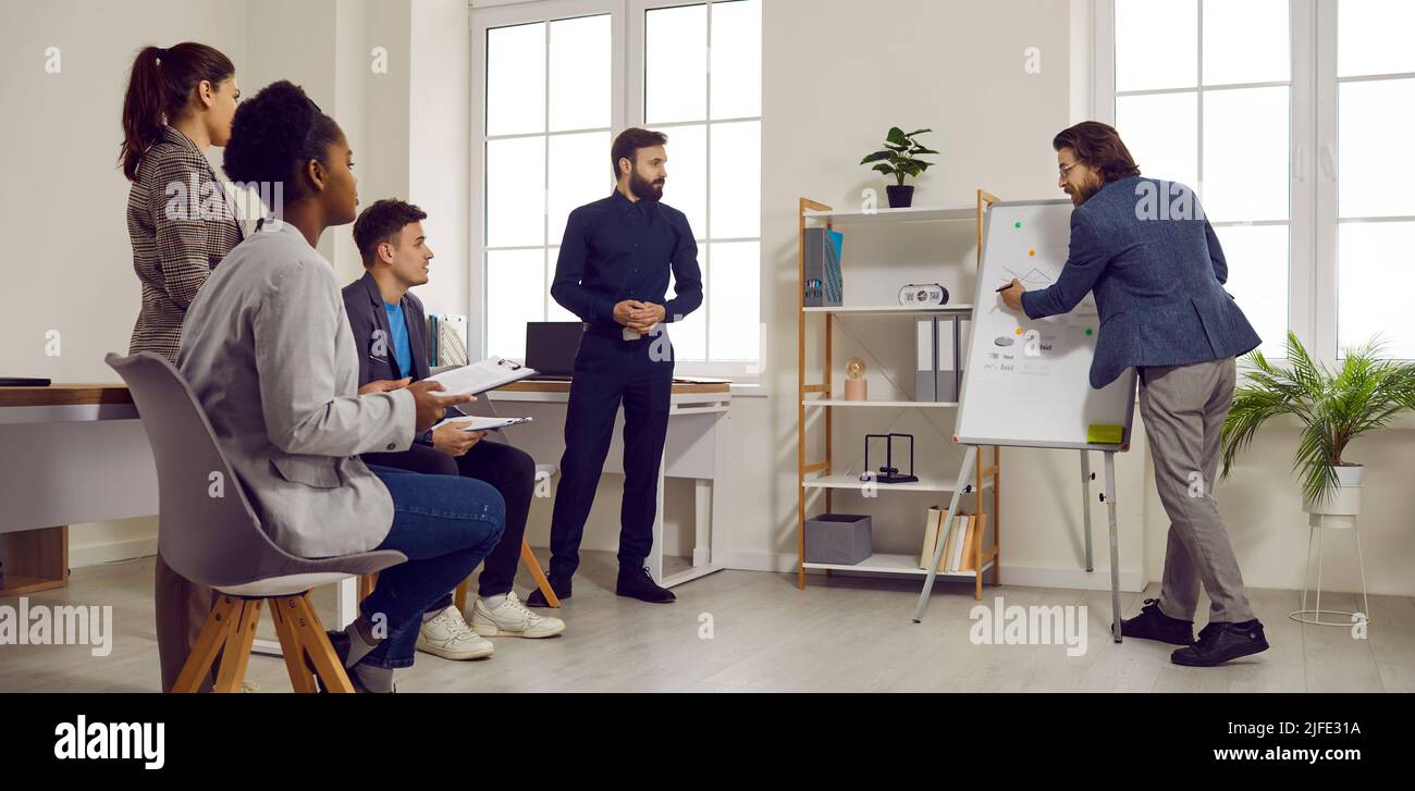 Coach gives presentation to business team and explains something using ...