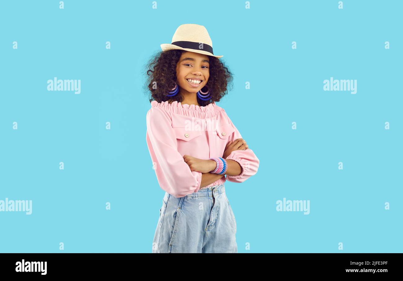 Portrait of happy child in stylish summer outfit standing isolated on blue background Stock Photo