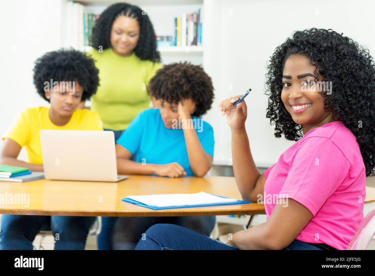 Pretty african american computer science student with group of coding students at university Stock Photo