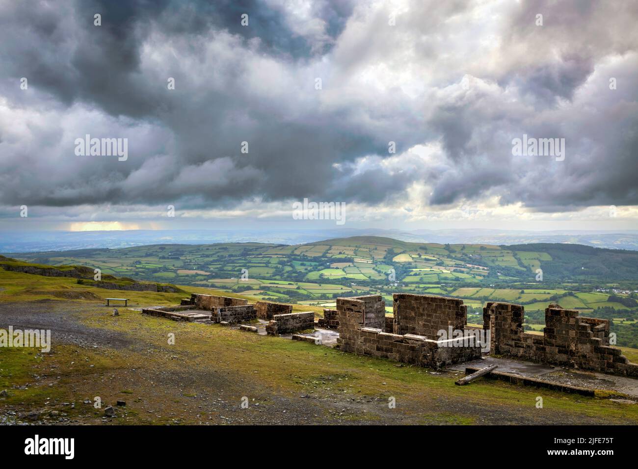 Billowing clouds at sunset over the old demolished buildings at Herbert's Quarry on the Black Mountain road in South Wales UK Stock Photo