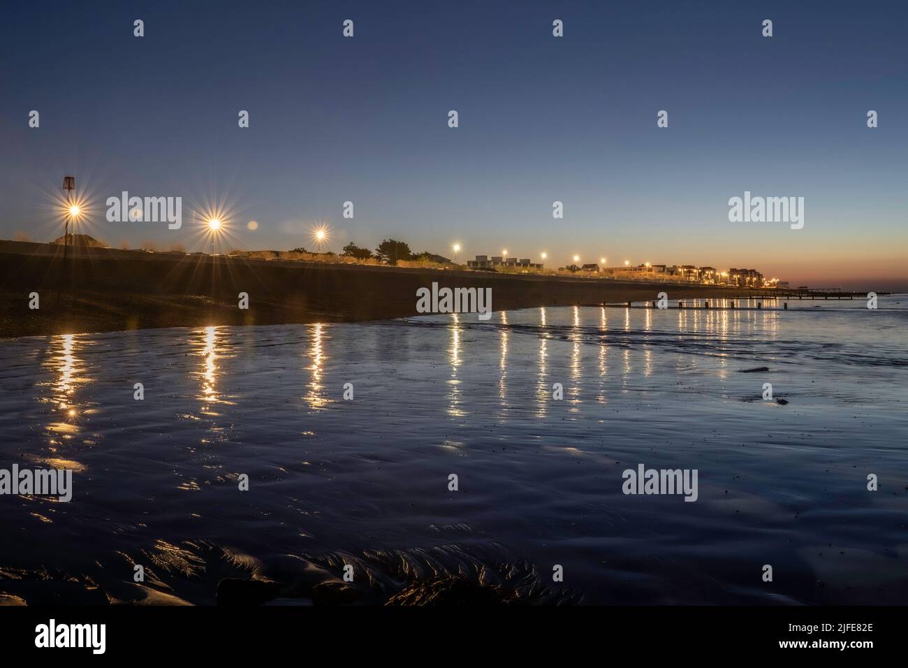 Bognor Regis beach and seafront on an early morning at dawn before sunrise with twinkling street lights. Stock Photo