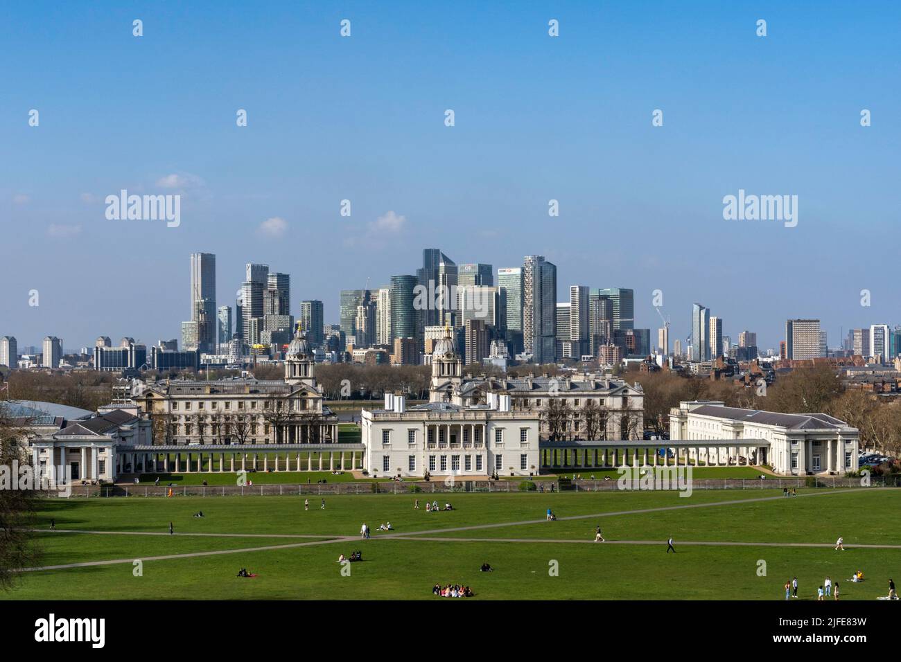 Greenwich Park in East London crisscrossed with paths showing the Queens building and Canary Wharf in the distance on a clear blue sky spring day. Stock Photo