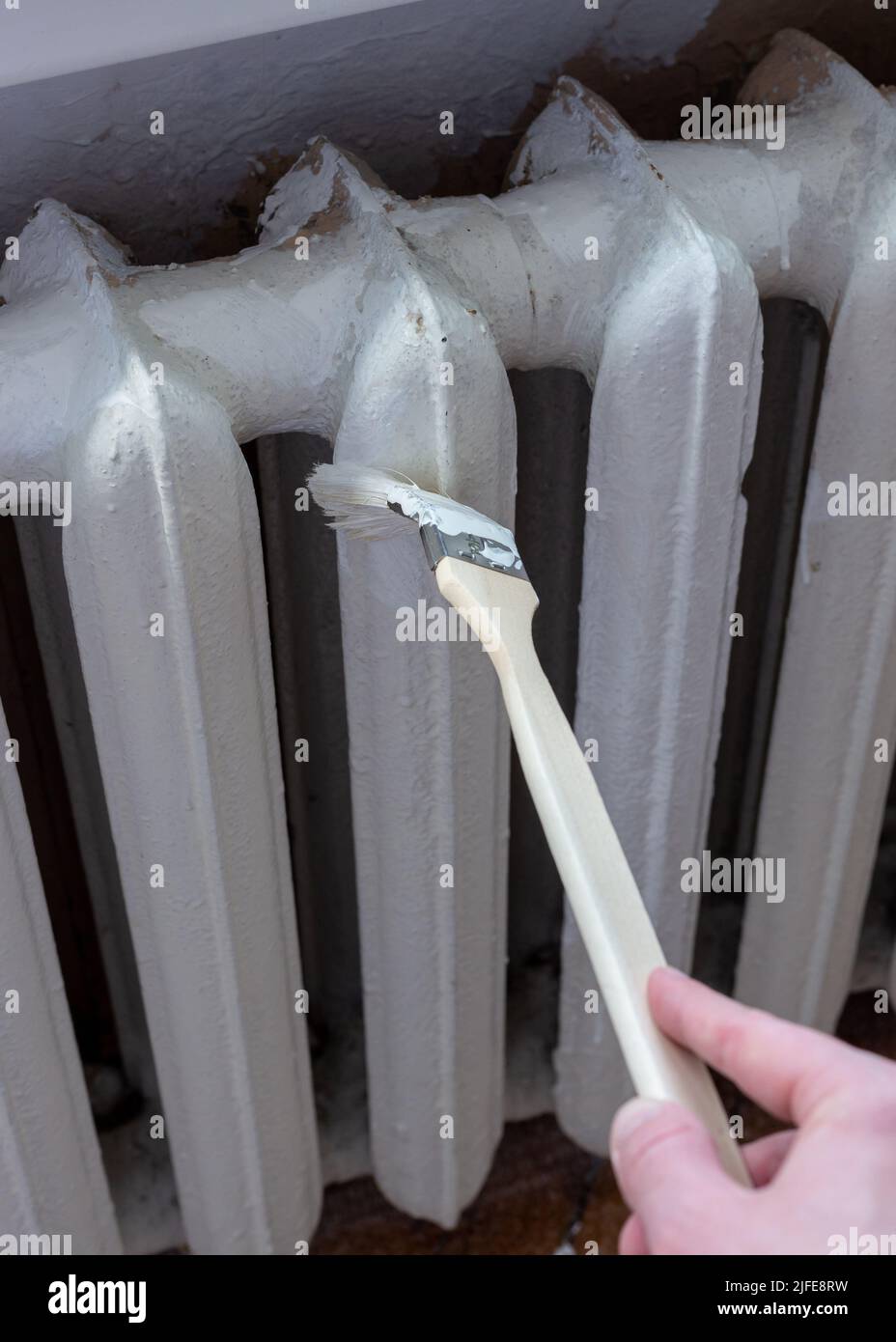 Painting radiators with a special brush. Battery painting Stock Photo