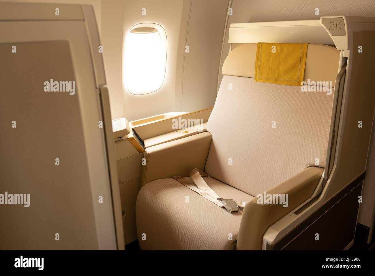 Luxury first or business class suite on airplane in gold color feel private for travel. Business comfort and elegance chair when fly with airline Stock Photo