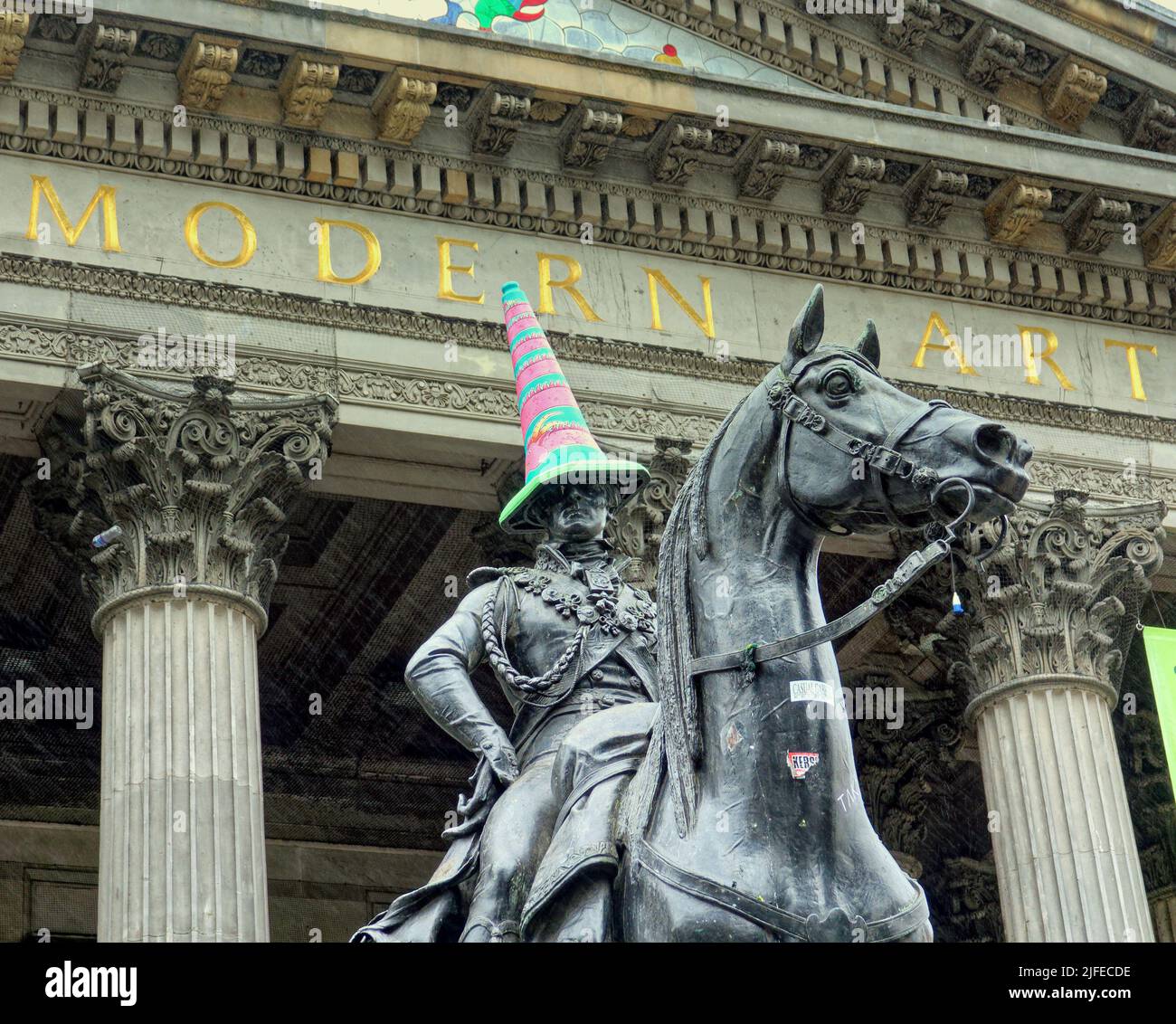 Glasgow, Scotland, UK 2nd July, 2022. Cone headed man gets transgender hat as the symbol for the city the duke of wellington statue gets a hat for gay week in transgender colours. Transgender Pride Flag was created by American trans woman Monica Helms in 1999, and was first shown at a pride parade in Phoenix, Arizona, United States in 2000 Credit Gerard Ferry/Alamy Live News Stock Photo