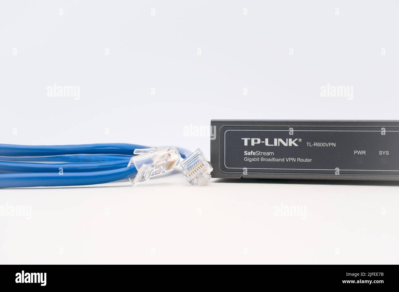 TPLINK broadband network router with network cables on a white desk