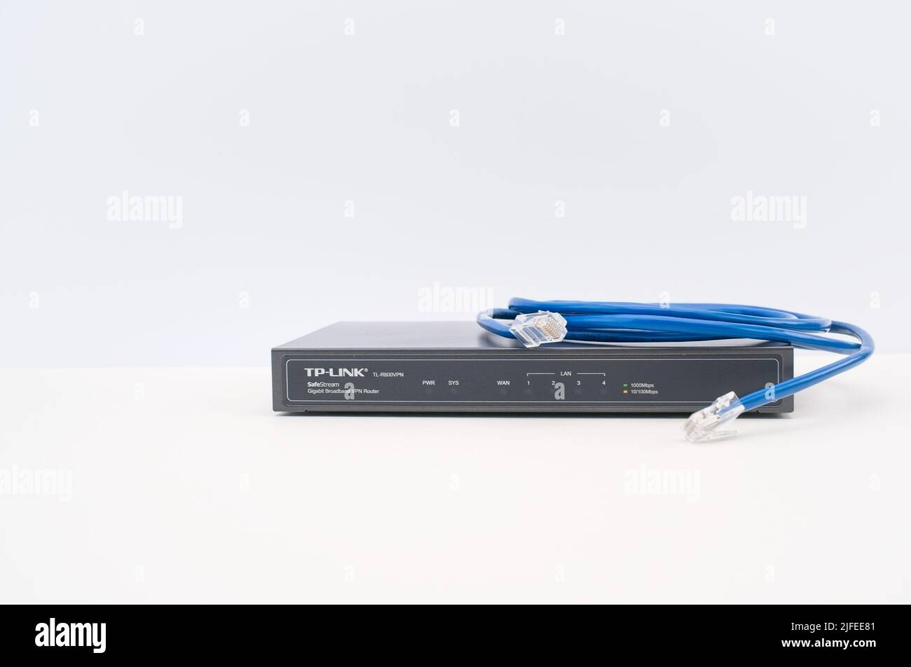 TPLINK broadband network router with network cables on a white desk