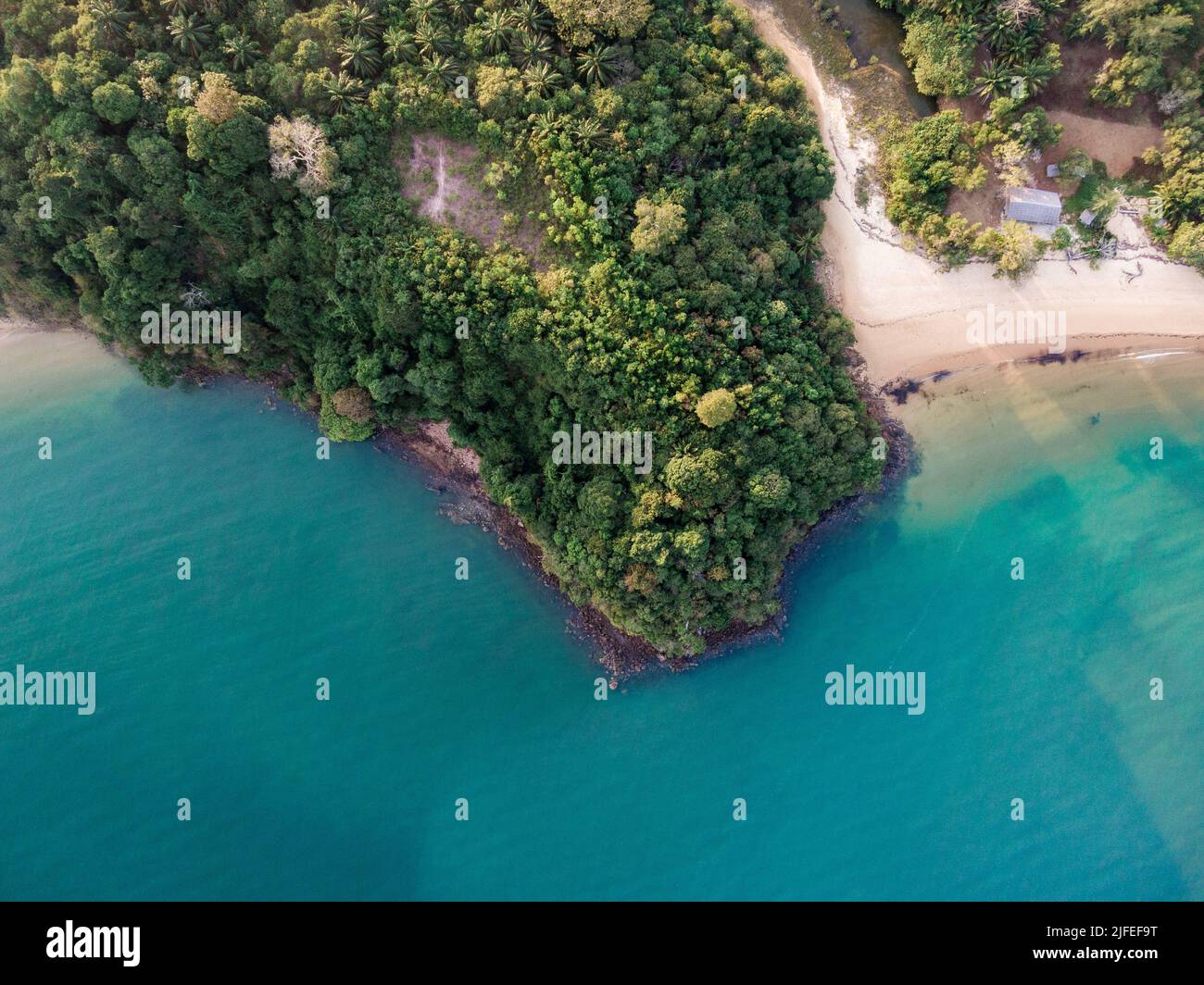 An aerial view of a green coastline and turquoise sea Stock Photo - Alamy