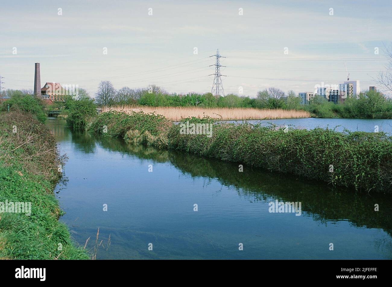 The Coppermill Stream in springtime on Walthamstow Wetlands, North London UK, looking towards the Engine House building Stock Photo