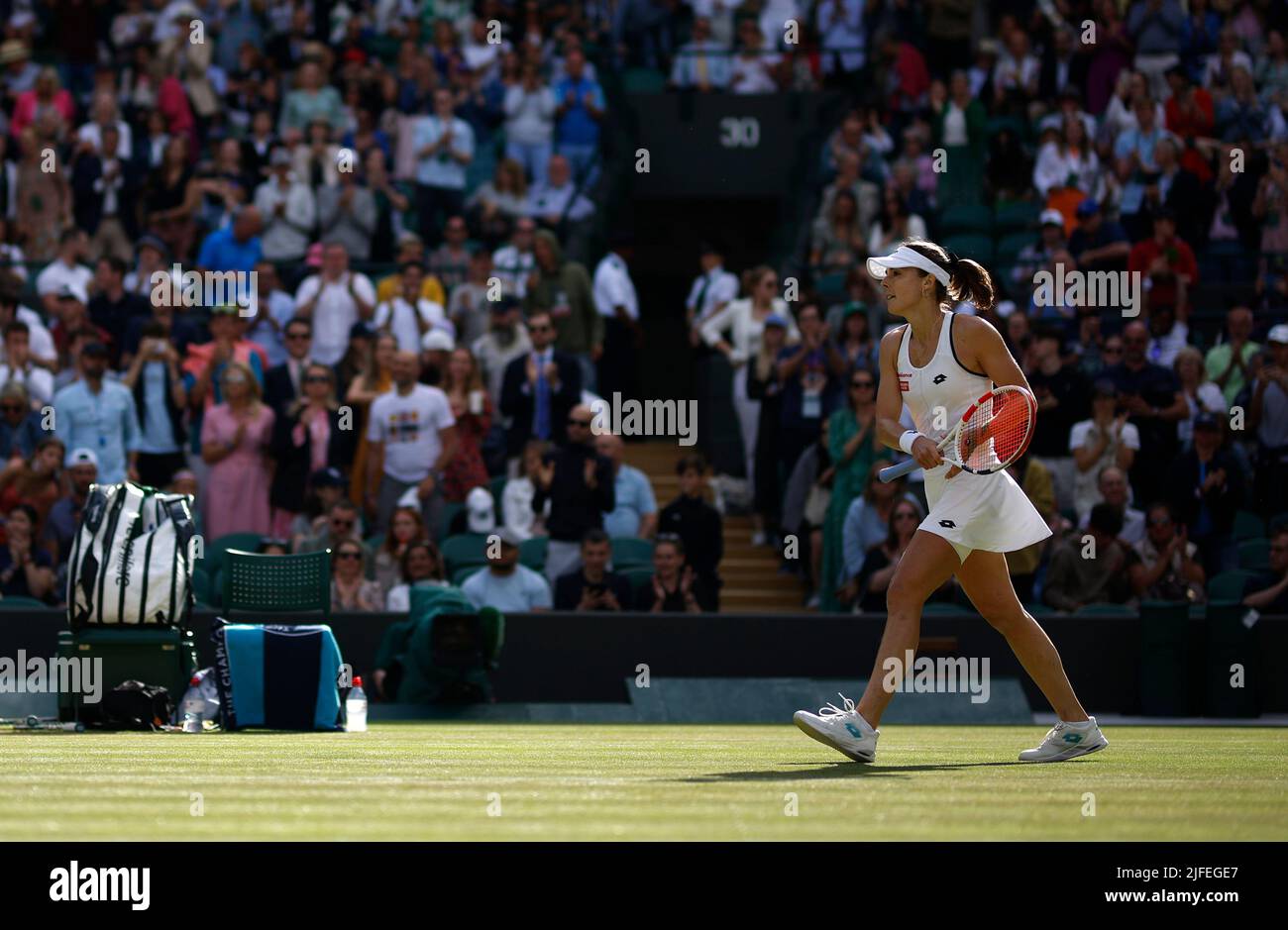 Alize goes to shake hands with Iga Swiatek after her Ladies