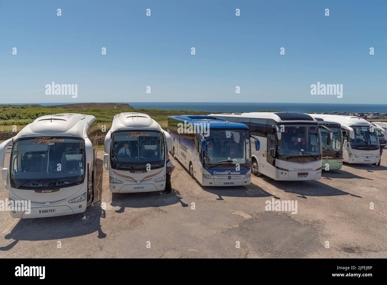 Cornwall, England, UK. 2022. Holiday coaches parked along the Cornish south west coast with the sea as a backdrop. Stock Photo