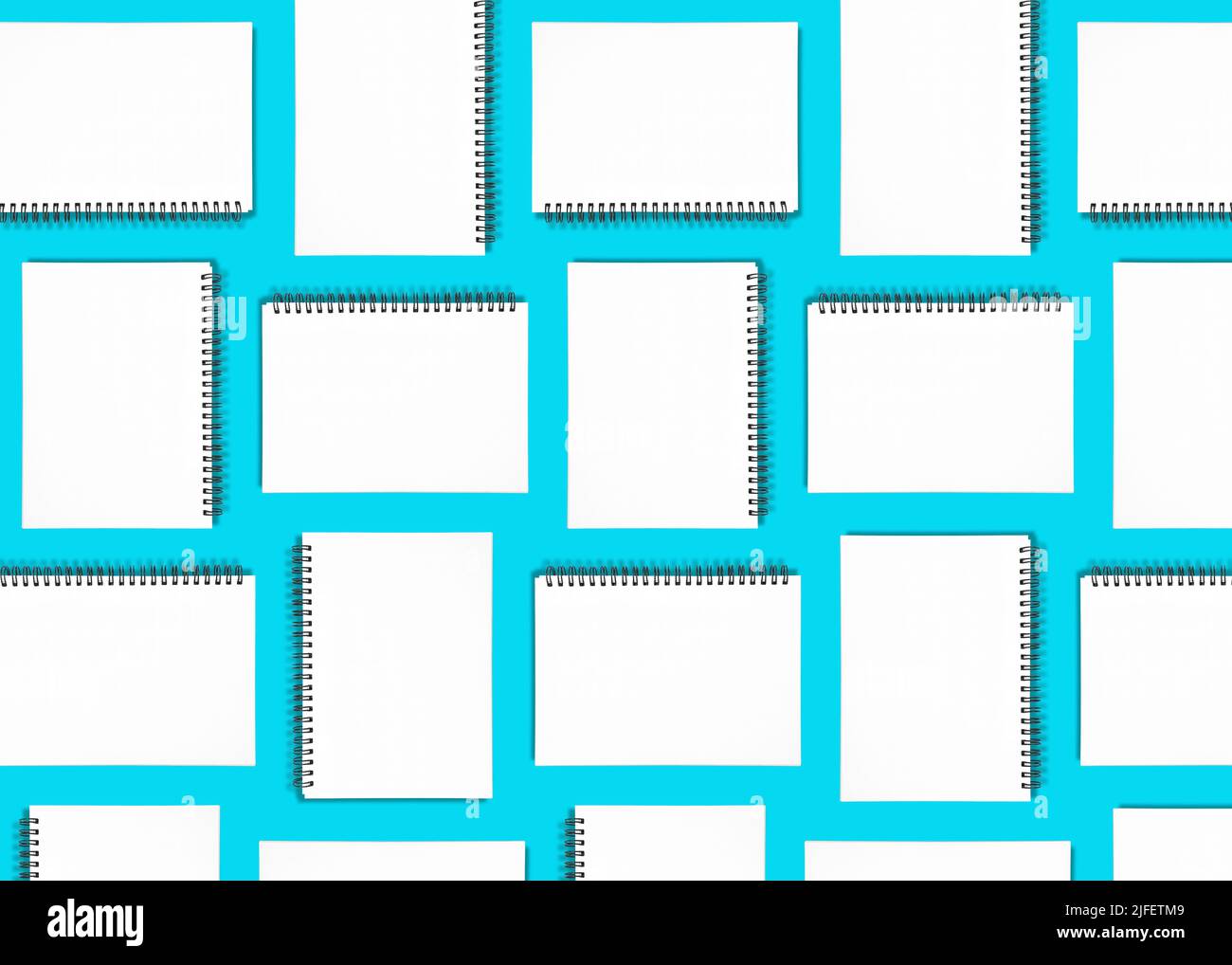 Pattern background made from spiral notebooks on blue Stock Photo