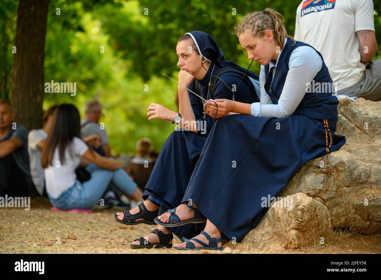 Two young nuns, among other pilgrims, listening to a catechesis during Mladifest 2021 – the youth festival – in Medjugorje. Stock Photo