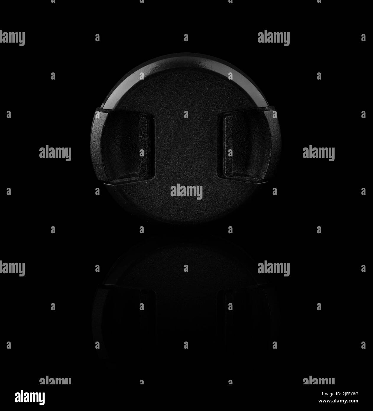 camera lens cap on a black background with reflection Stock Photo Alamy