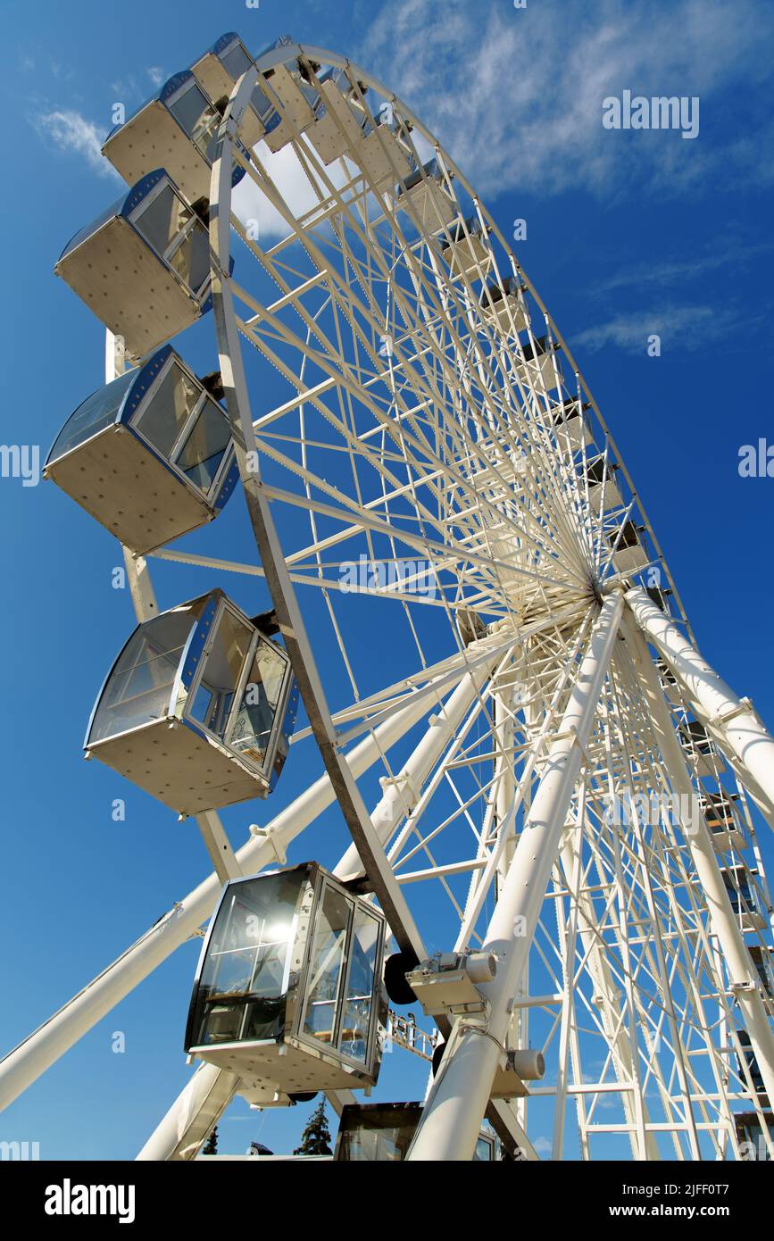 Ferris wheel against blue sky. Modern white ferris wheel. Bottom view Stock Photo