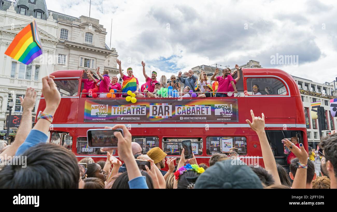London Pride parade celebrating the 50th anniversary of the LGBTQ event. Bus with people having fun and waving rainbow flags. London - 2nd July 2022 Stock Photo