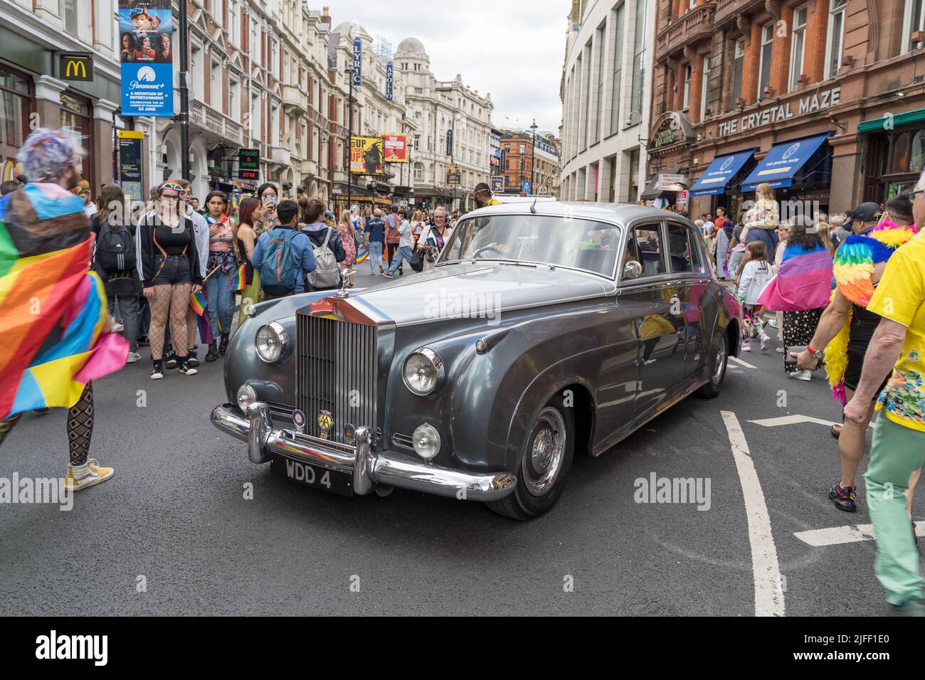 London Pride parade celebrating the 50th anniversary of the LGBTQ event. A silver Rolls Royce in Shaftesbury Avenue surrounded by people. London 2022 Stock Photo