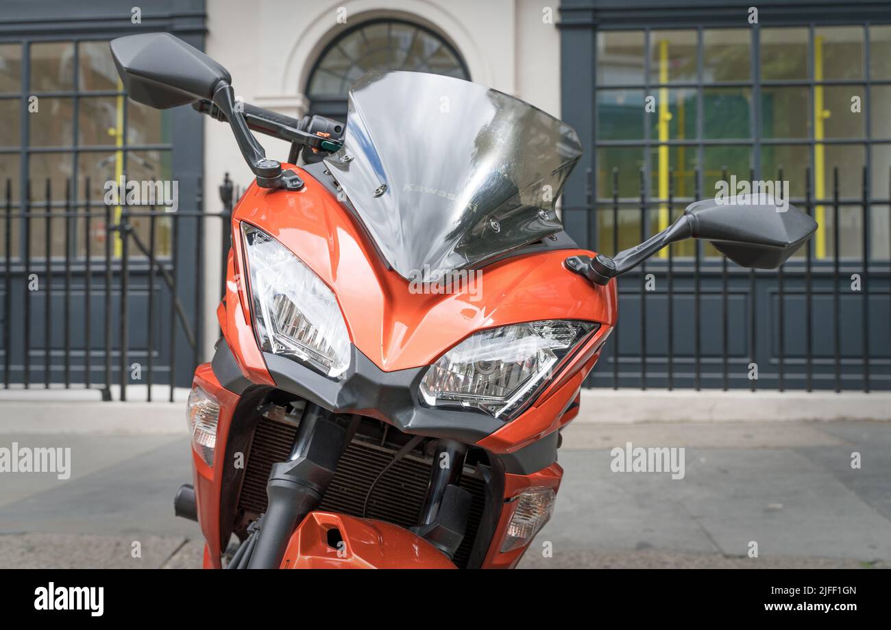 Close up of an orange Kawasaki motorbike on the pavement. Stock Photo