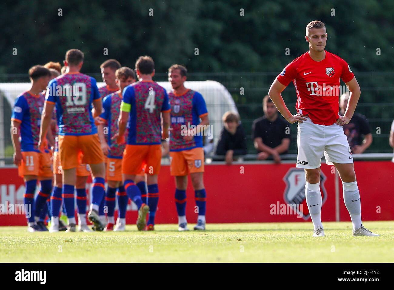 UTRECHT, NETHERLANDS - JULY 2: Rick Meissen of FC Utrecht is looking dejected while players of Queens Park FC are celebrating a goal during the Preseason match between FC Utrecht and Queens Park at Sportpark Zoudenbalch on July 2, 2022 in Utrecht, Netherlands (Photo by Ben Gal/Orange Pictures) Stock Photo