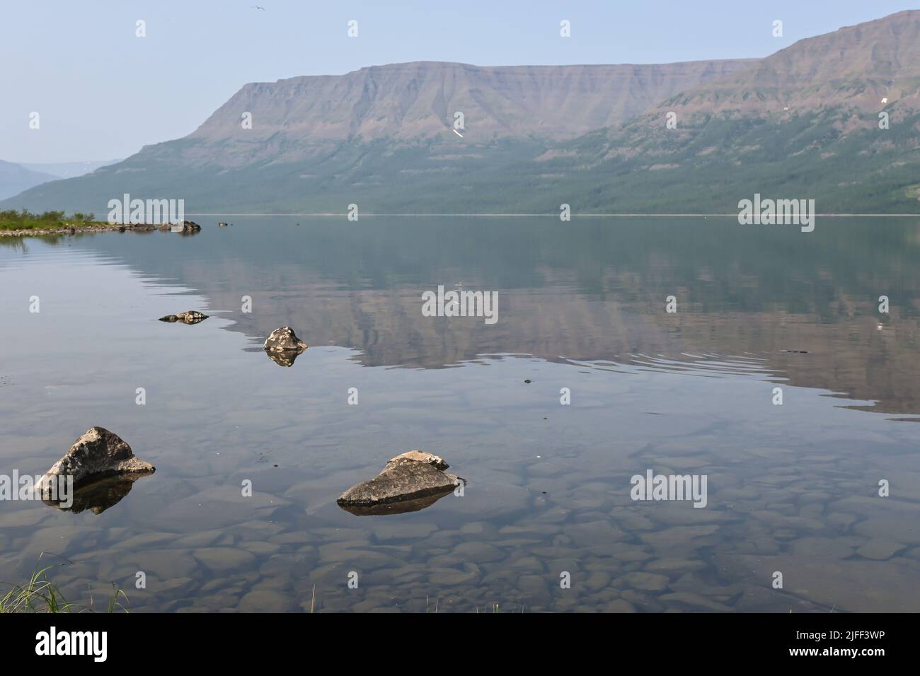 A mountain lake in a misty haze. Water landscape of the Putorana ...