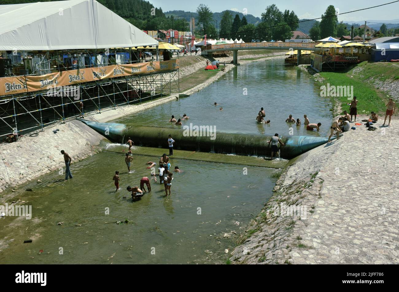 gypsy community cooling off and catching small fish by the hands in the shallow waters of the Bjelica river in Guca, Serbia Stock Photo