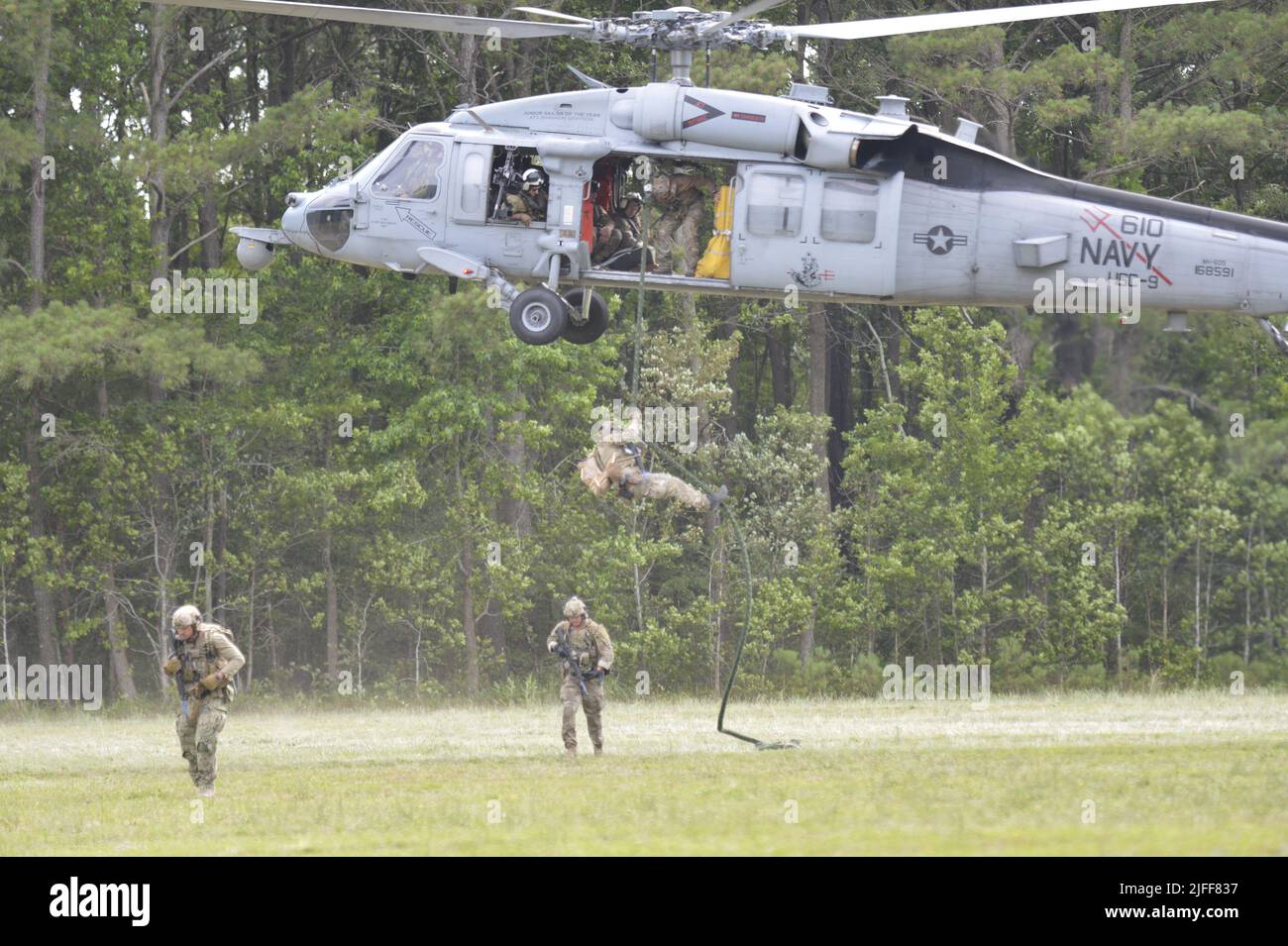 VIRGINIA BEACH, Va. (Jun. 29, 2022)- Explosive Ordnance Disposal Technicians assigned to Explosive Ordnance Disposal Mobile Unit (EODMU) 2 fast-rope from the cabin of an SH-60S Sea Hawk helicopter assigned to Helicopter Sea Combat squadron (HSC) 9. CRABEx is a training exercise that certifies Navy EOD units of action under Explosive Ordnance Disposal Group (EODGRU) 2, ensuring a ready and more lethal EOD force. Stock Photo
