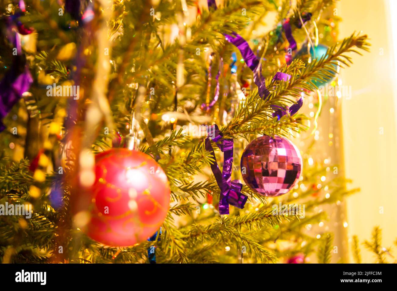 The holiday is a new year or Christmas, in the photo a live fir tree is decorated with toys, tinsel and beads. Retro. - Stock Image