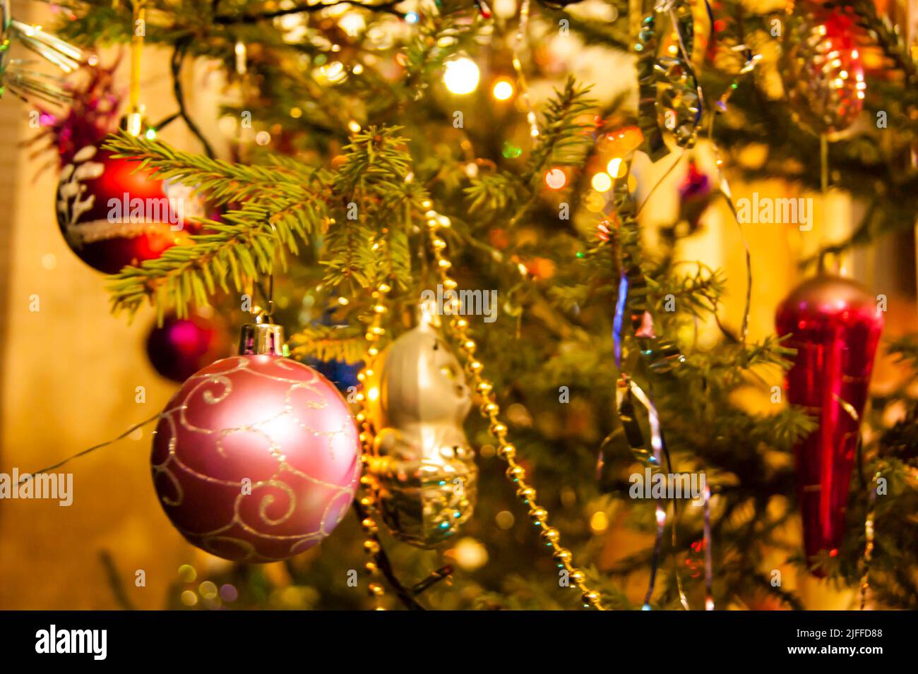 The holiday is a new year or Christmas, in the photo a live fir tree is decorated with toys, tinsel and beads. Retro. - Stock Image