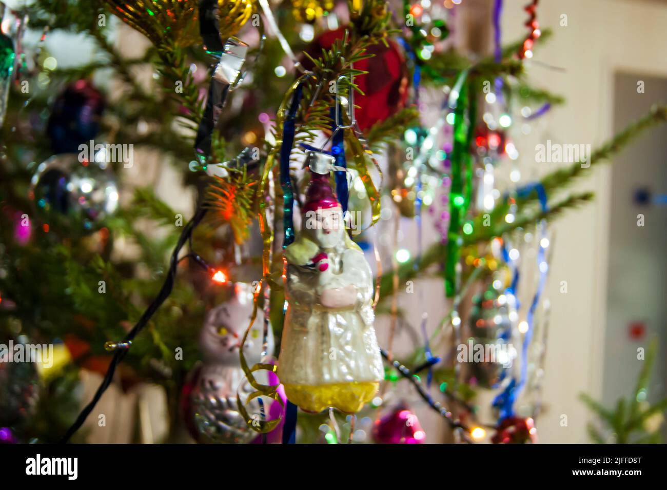 The holiday is a new year or Christmas, in the photo a live fir tree is decorated with toys, tinsel and beads. Retro. - Stock Image