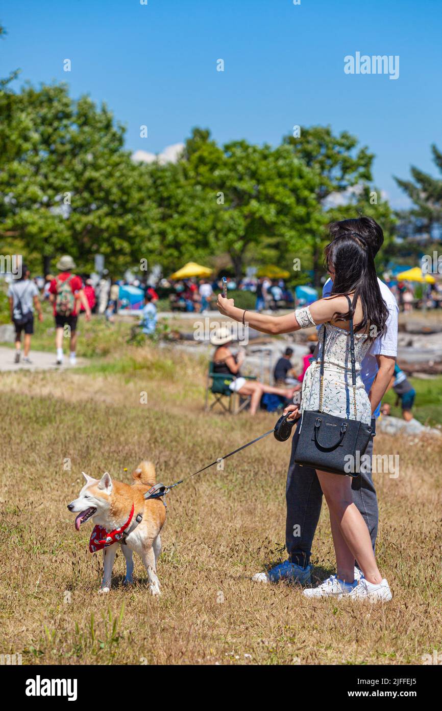 Young couple with a dog taking a selfie in Steveston on Canada Day 2022 Stock Photo