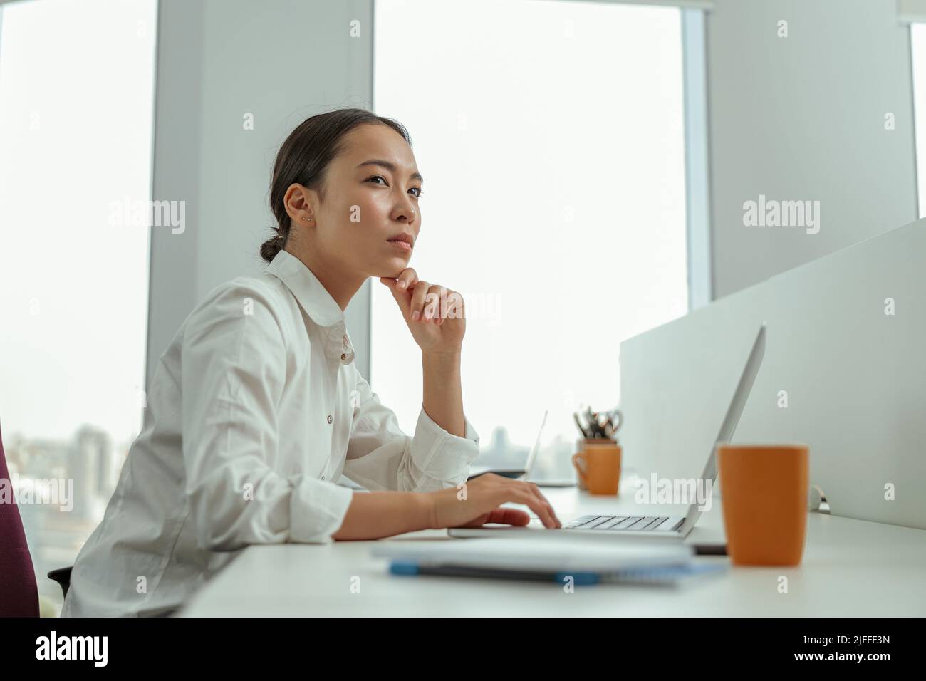Focused asian business woman working laptop sitting in modern office ...