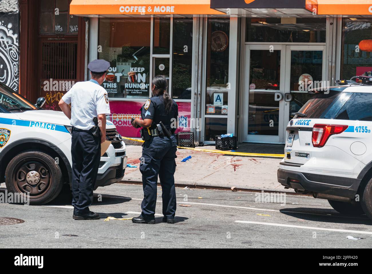 July 2, 2022: an NYPD commander speaks with officers in front of the scene of a shooting in Manhattan's Lower East Side, New York Stock Photo
