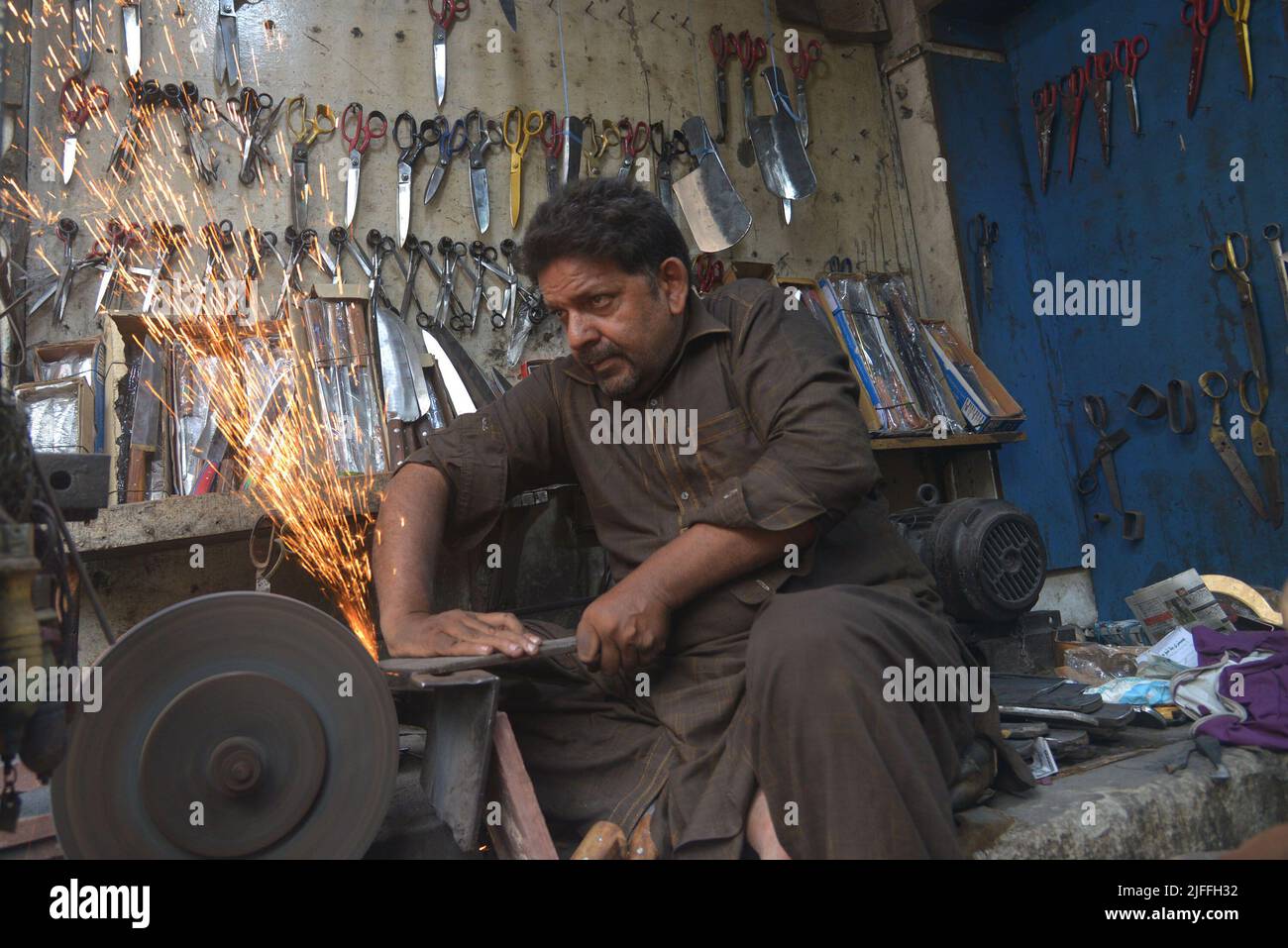 July 2, 2022, Lahore, Punjab, Pakistan Pakistani blacksmiths sharpens