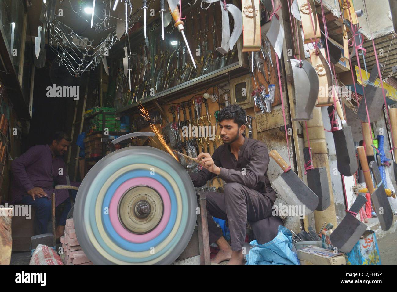 July 2, 2022, Lahore, Punjab, Pakistan Pakistani blacksmiths sharpens
