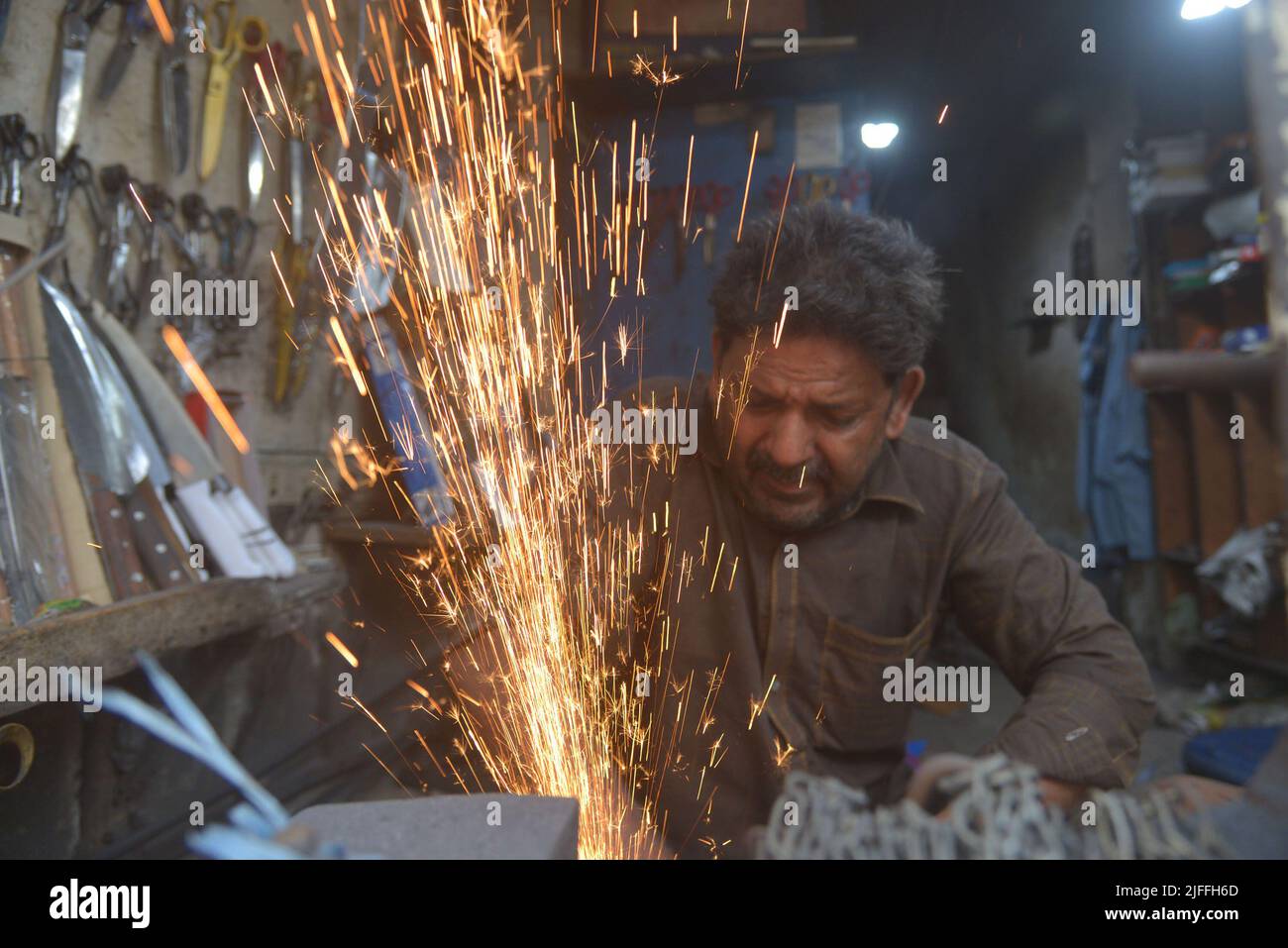 July 2, 2022, Lahore, Punjab, Pakistan Pakistani blacksmiths sharpens