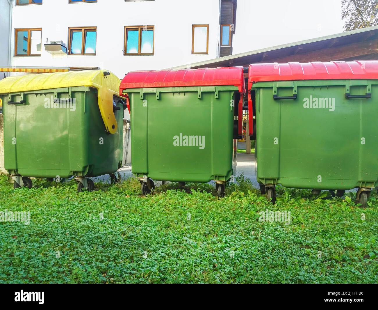 Garbage cans in different colors for waste management, trash recycling