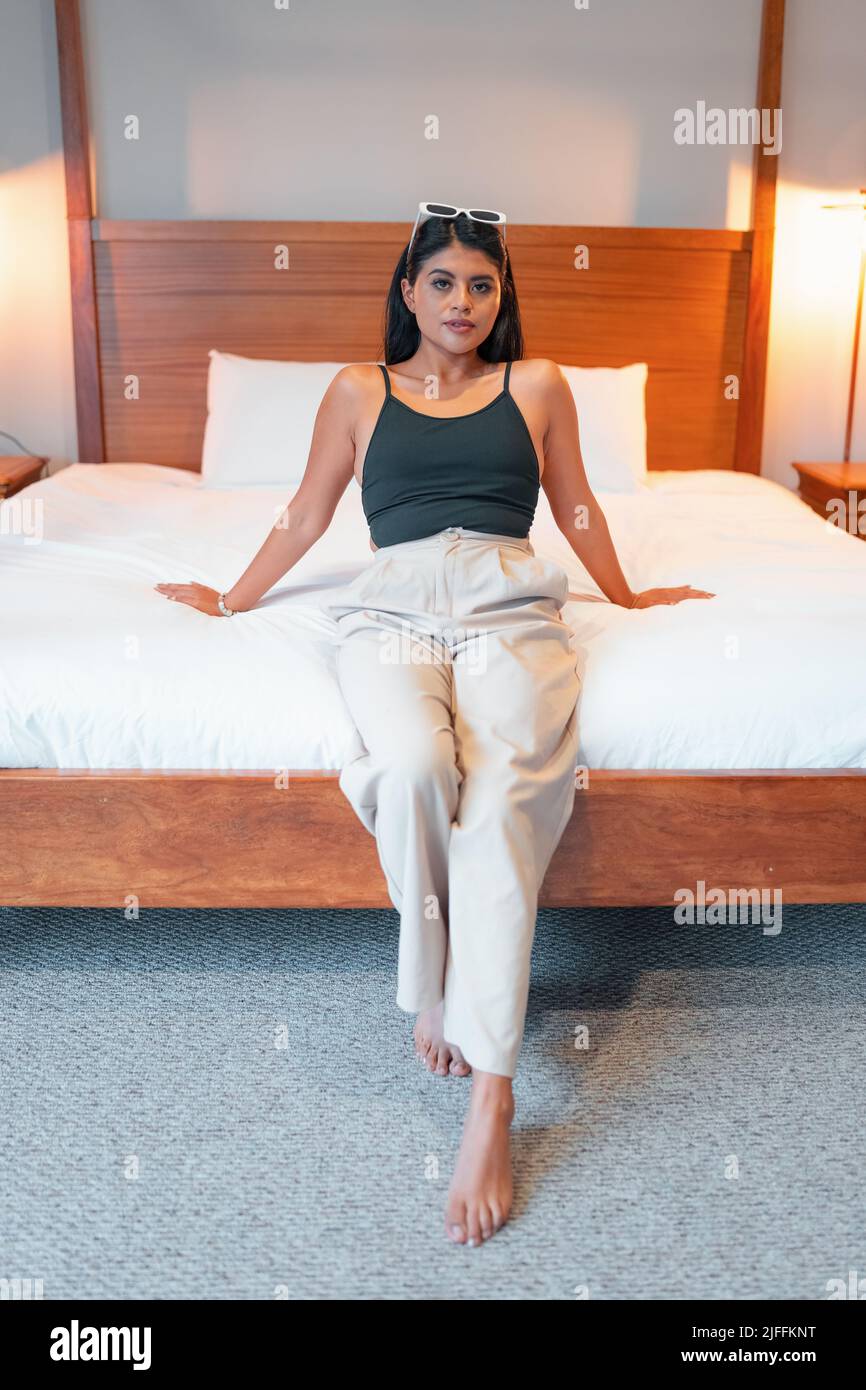 sitting on the edge of a comfortable bed in the interior of the room a ...