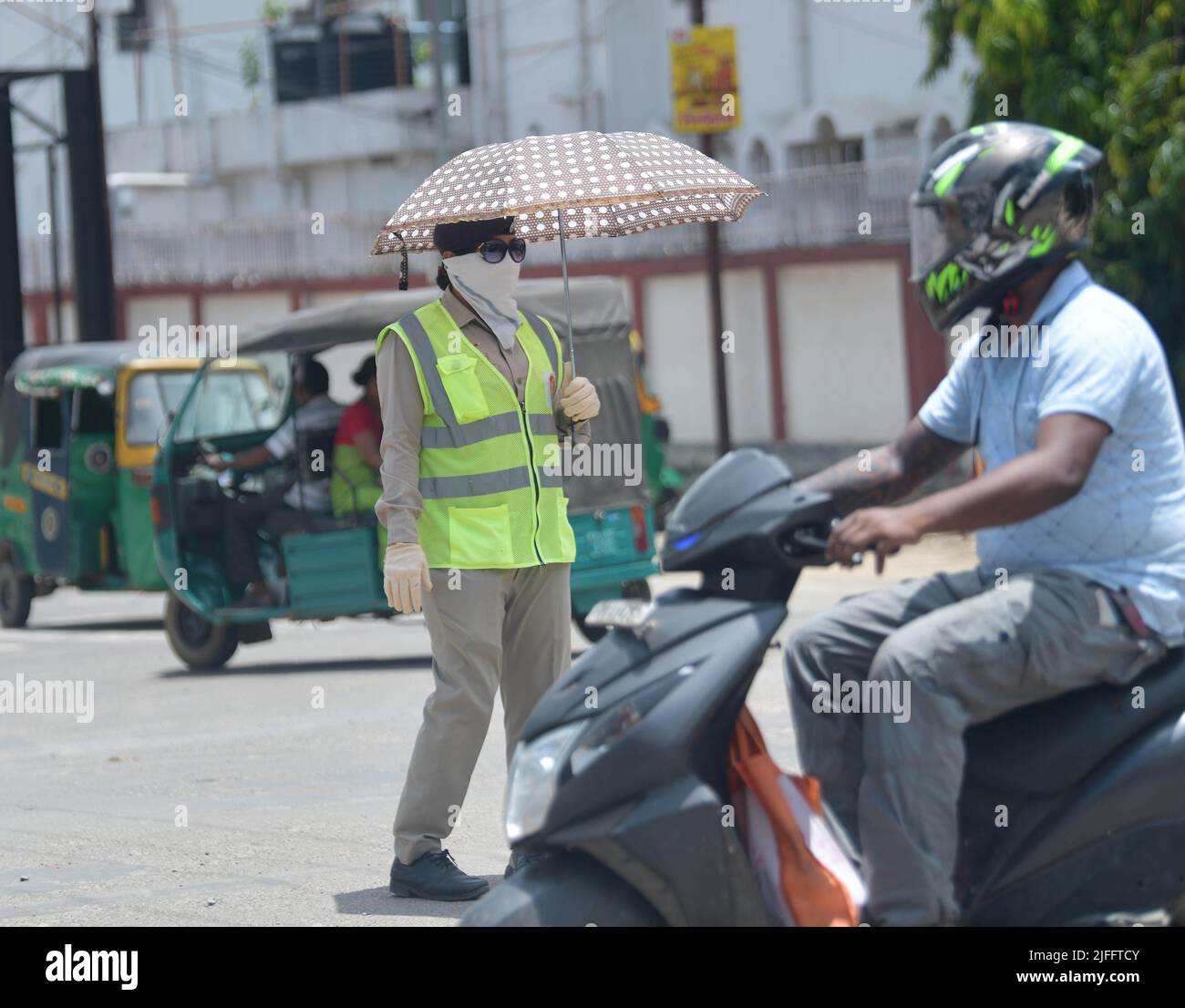 A female traffic police officer maintaining traffic with an umbrella on