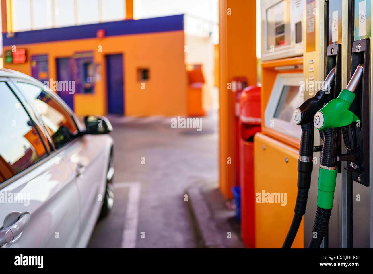 Car parked at a gas station, ready to refuel from the hoses Stock Photo