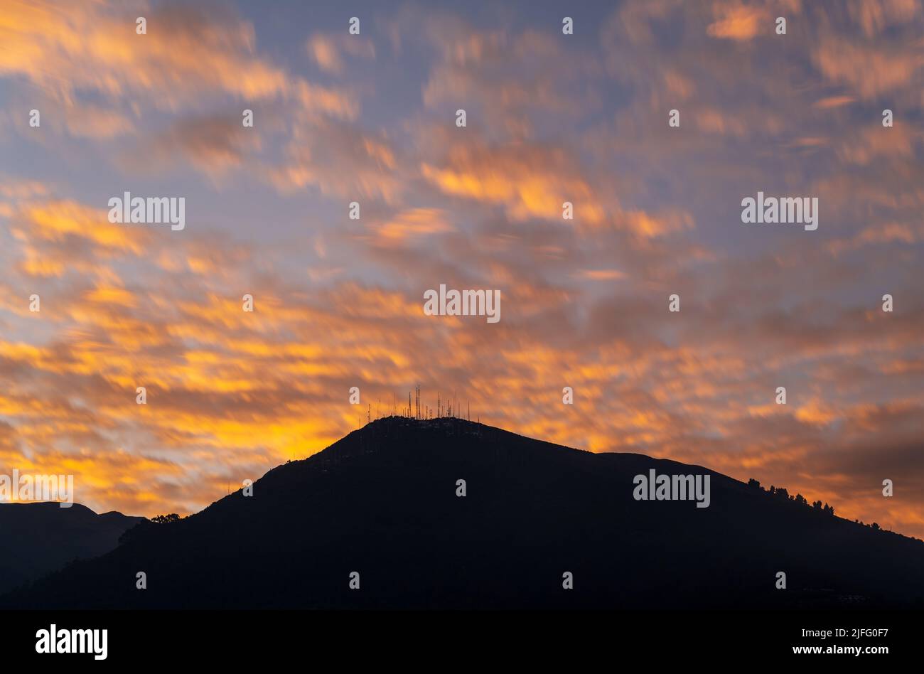 Long exposure sunset with the antenna peak (3920m altitude) of the Pichincha volcano, Quito, Ecuador. Stock Photo